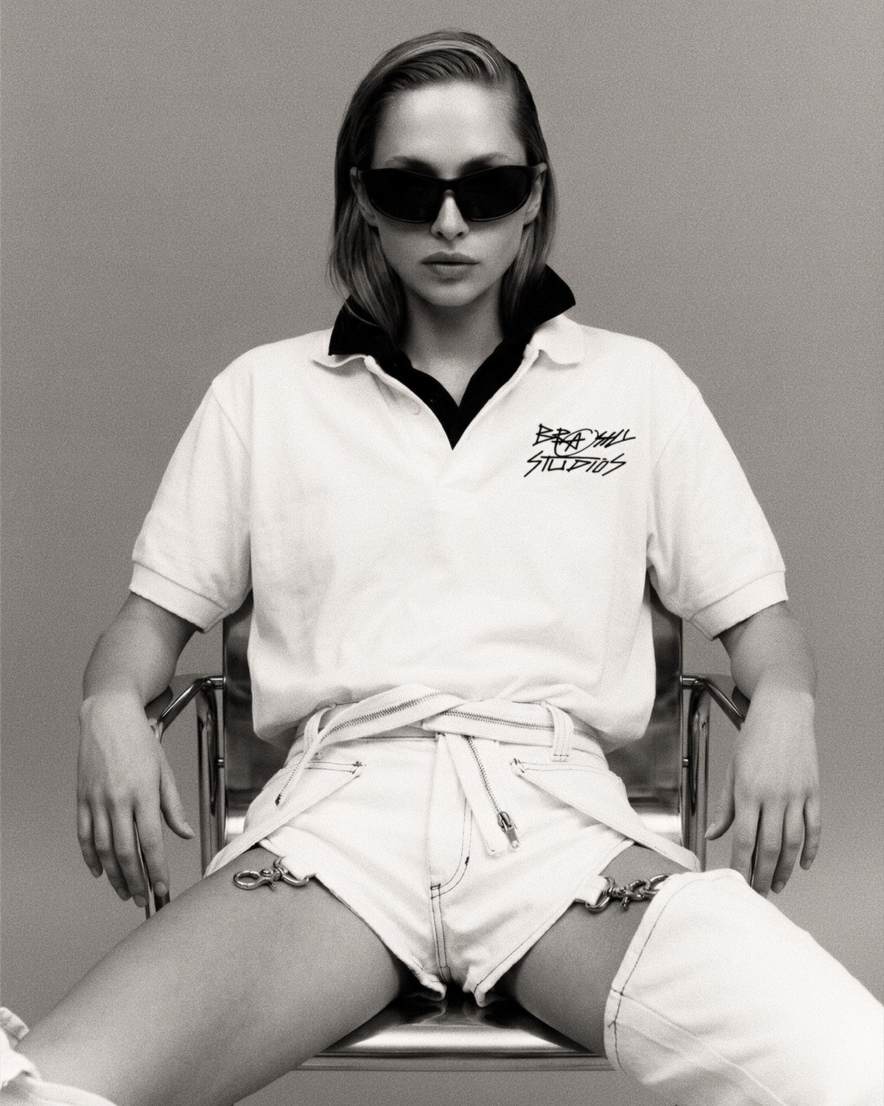 Editorial image with a handwritten chest mark and chain-hung deconstructed shorts.