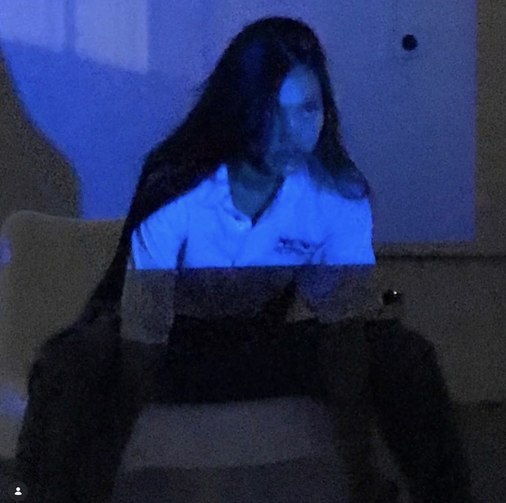 Projection falls across a figure and the wall behind.