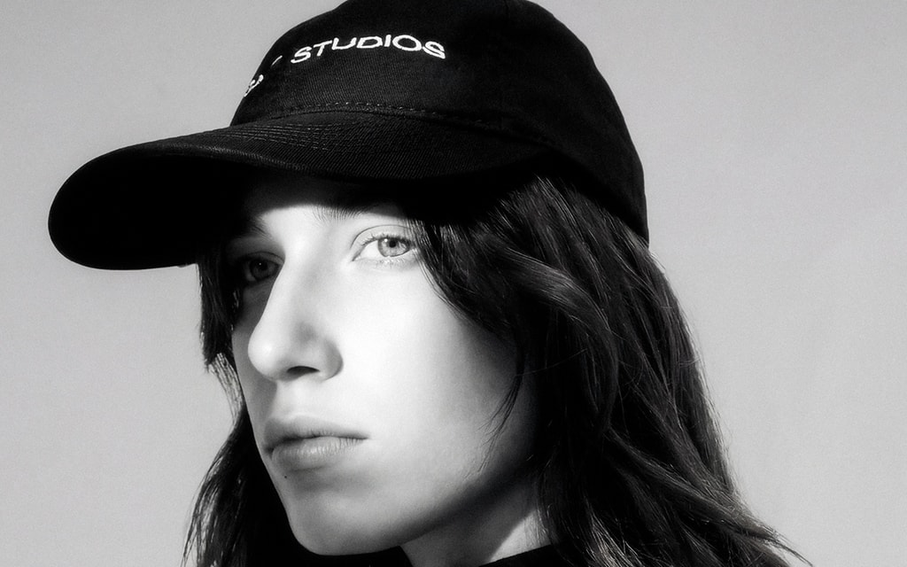 Black-and-white campaign portrait, close cropped, with a dark Brashy cap.