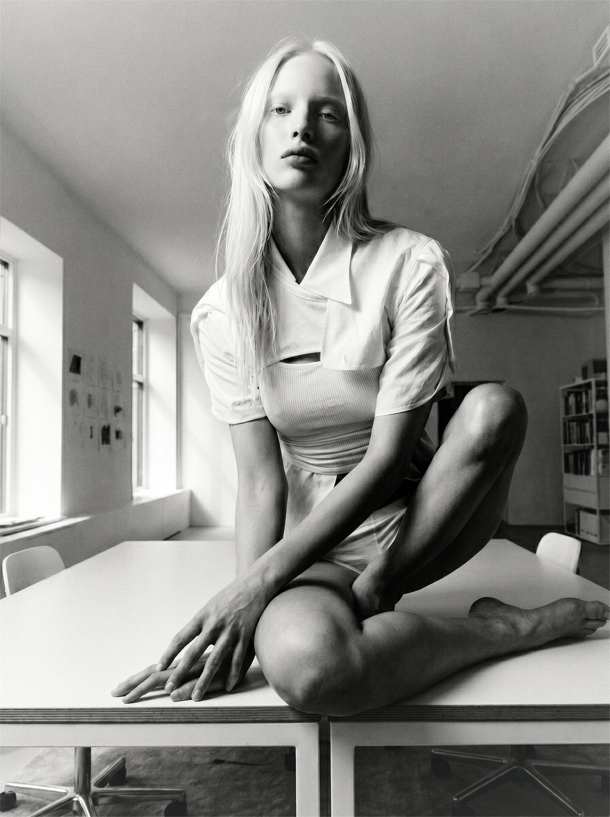 Sonya Esman — a commissioned black-and-white editorial: a figure seated on a studio table in daylight