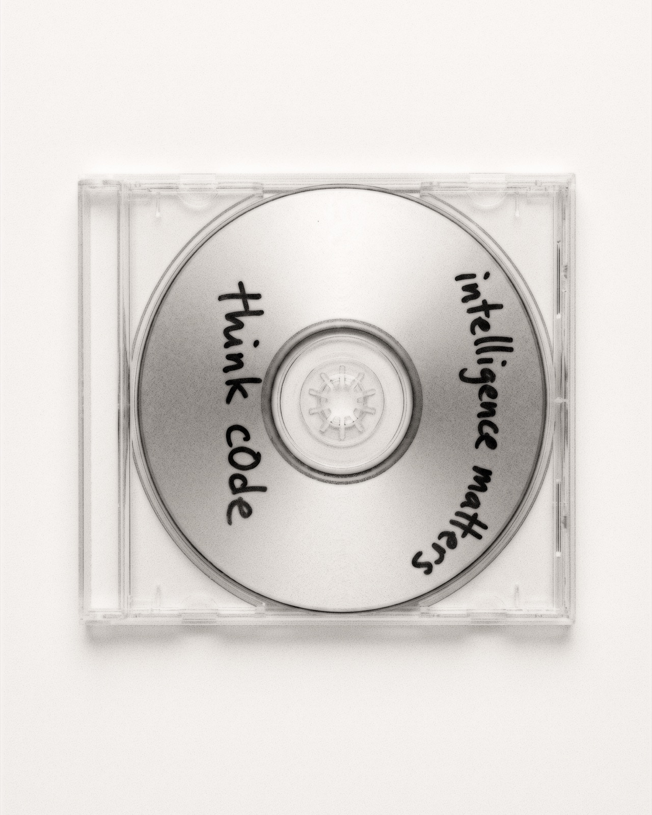 Hand-lettered CD-R, 'think c0de' drawn across the disc in black marker.