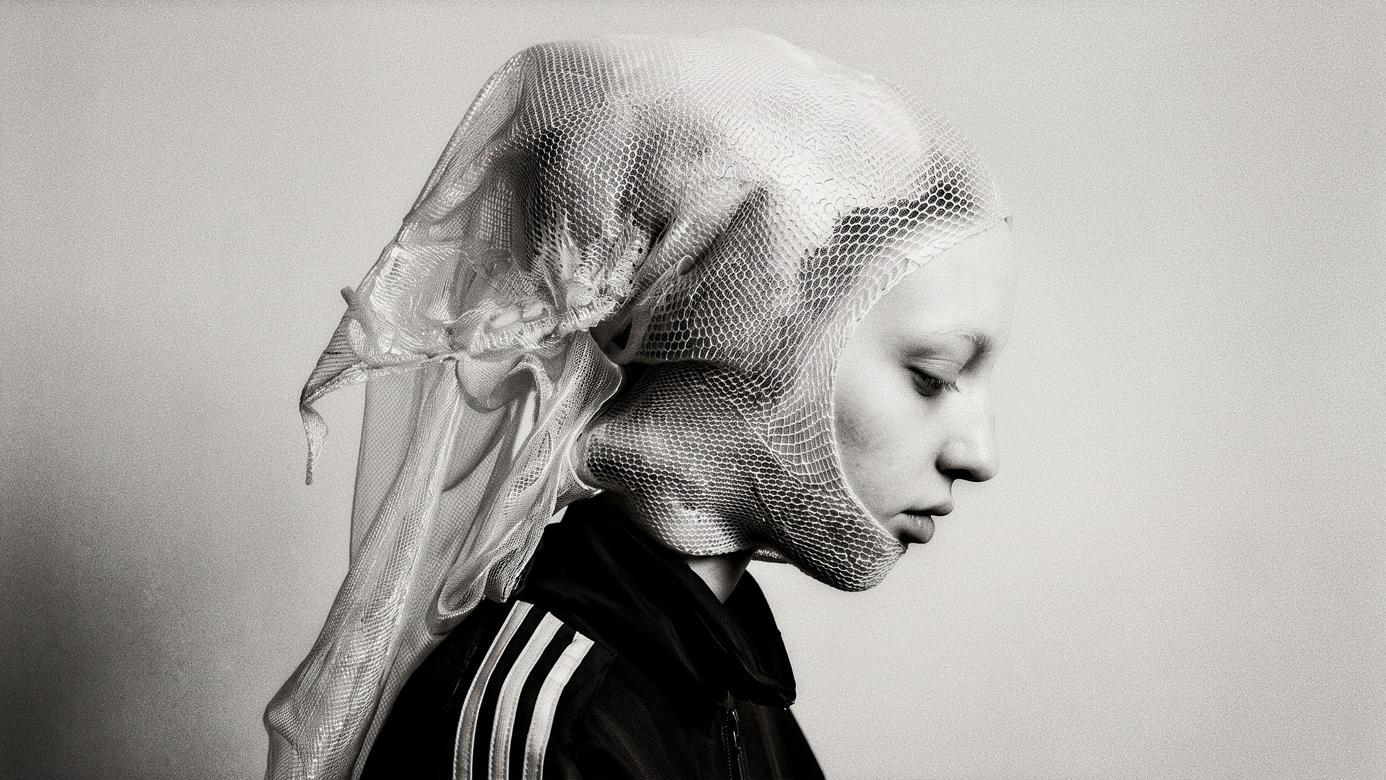 Black-and-white profile wrapped in translucent mesh.