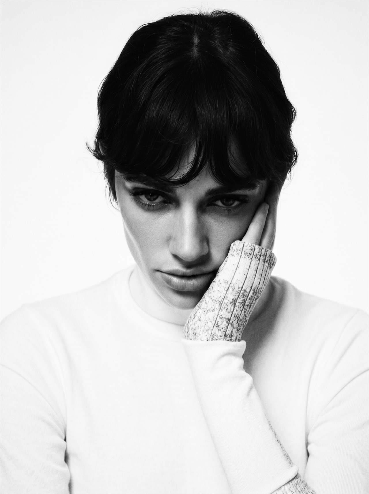 NIIA — close high-key portrait in white, a lace glove held against the cheek, B&W.