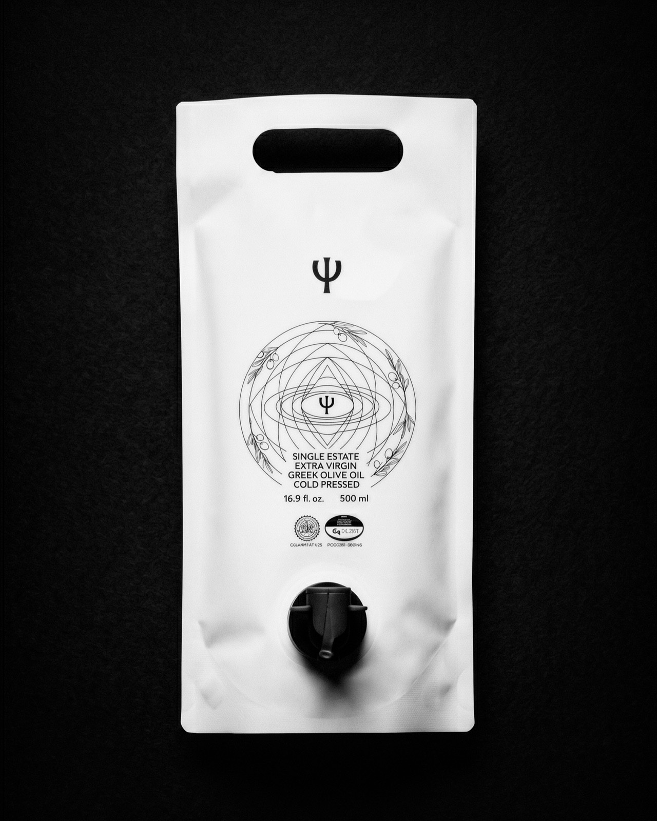 White Psyche olive-oil pouch on a black ground: the Ψ trident mark above a fine-line mandala of olive branches, with a black spout tap below.
